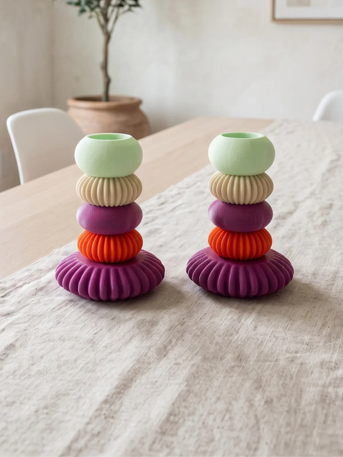İki MACARON şamdan, yemek masasındaki keten runner üzerinde yan yana